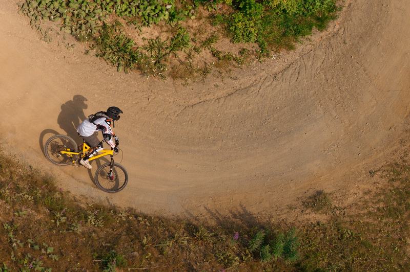 Rider in einer Anliegerkurve im Bikepark Winterberg, von oben